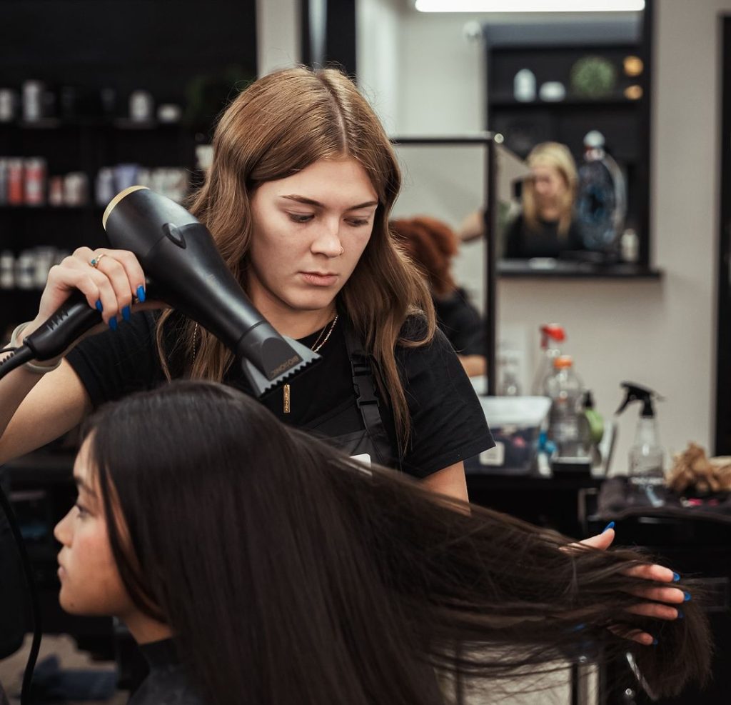 Centralia Beauty School student blowdrying a woman's hair